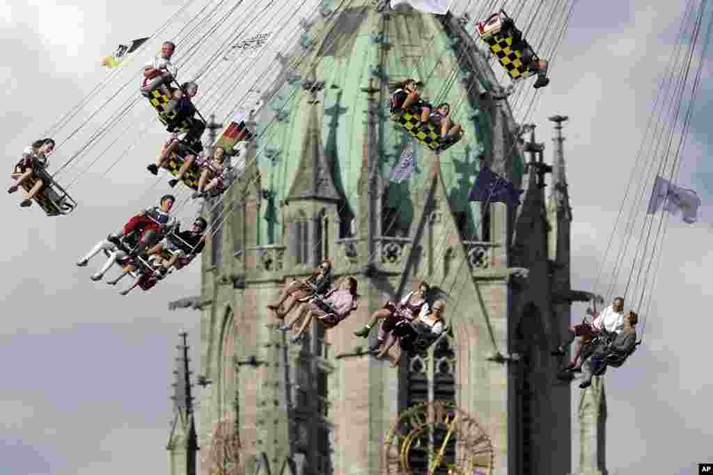 Warga menaiki &quot;komedi putar&quot; di depan gereja St. Paul pada festival Oktoberfest di Munich, Jerman.
