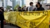 资料照：香港民众举着横幅在法庭外，为在新国安法下被拘留的47名活动人士表示支持。 （美联社2021年3月1日拍摄)