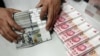 一家银行里工作人员正在清点人民币和美元