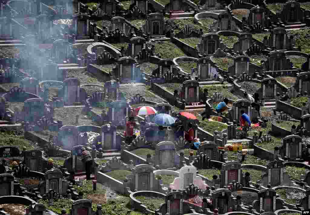 Ethnic Chinese Malaysians visit the graves of their ancestors at a cemetery on the eve of the annual &#39;Qingming&#39; festival in Kuala Lumpur.