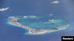 Chinese dredging vessels are purportedly seen the waters around Mischief Reef in the disputed Spratly Islands in the South China Sea in this video image taken by a P-8A Poseidon surveillance aircraft provided by the U.S. Navy, May 21, 2015. 
