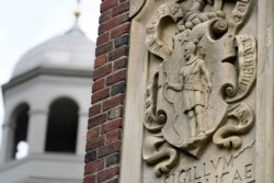 FILE - An image of a Native American, right, is featured in the artwork of Johnston Gate, Harvard University's first and largest gate heading to its campus, in Cambridge, Massachusetts, May 23, 2021.