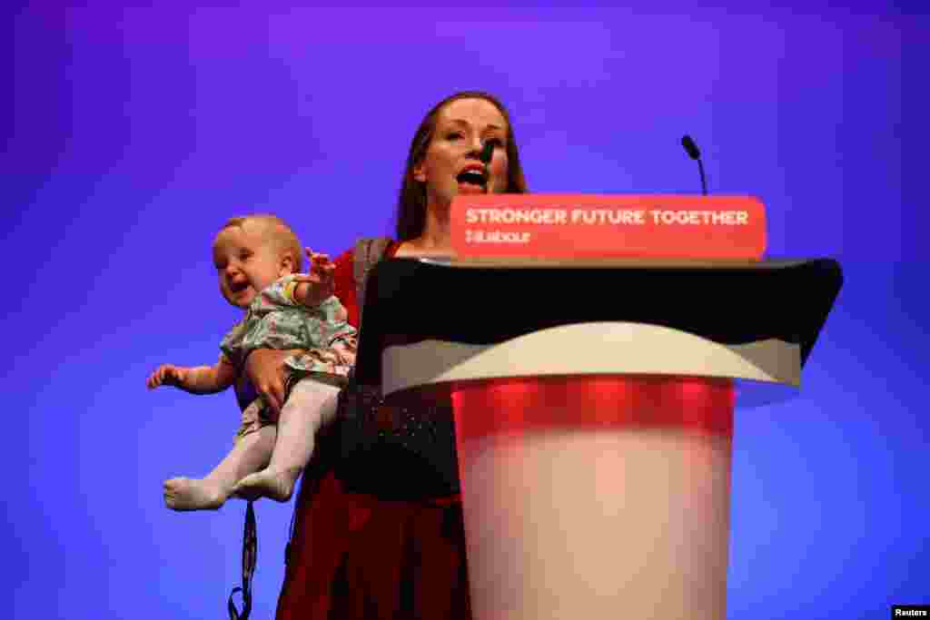 Delegate Catherine Atkinson speaks as she carries her 9-month-old Elena, during Britain&#39;s Labor Party annual conference in Brighton, Britain.