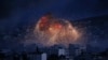 FILE - In this Oct. 20, 2014 file photo, thick smoke and flames erupt from an airstrike by the U.S.-led coalition in Kobani, Syria, as seen from a hilltop on the outskirts of Suruc, at the Turkey-Syria border. For Syrians marking seven years of war…