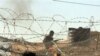 An Egyptian soldier (top R) takes position in the Egyptian side of Rafah as Palestinian demonstrators stand on their side of the divided border town during clashes, 06 Jan 2010