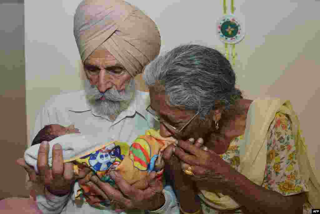 Indian father Mohinder Singh Gill, 79, and his wife Daljinder Kaur, 70, hold their newborn baby boy, Arman, at their home in Amritsar. Daljinder Kaur gave birth to a boy last month following two years of IVF treatment with her husband at a fertility clinic in the northern state of Haryana.