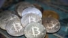 This illustration photograph taken on July 19, 2021 in Istanbul shows a physical banknote and coin imitations of the Bitcoin crypto currency. (Photo by Ozan KOSE / AFP)
