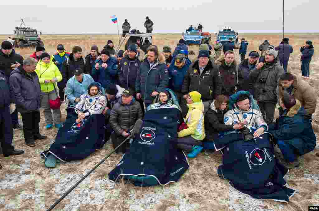 Russian cosmonauts Mikhail Kornienko, left, Sergey Volkov of Roscosmos, center, and Expedition 46 Commander Scott Kelly of NASA, rest in chairs outside of the Soyuz TMA-18M spacecraft just minutes after they landed in a remote area near the town of Zhezkazgan, Kazakhstan.