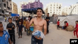 Palestinci prikupljaju namirnice iz bačenih paketa pomoći u oblasti Hamad City u Khan Yunisu u južnom pojasu Gaze 4. jula 2024.