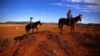FILE - Farmer Scott Cooper and his daughter Charlie ride their horses along a fence in a drought-affected paddock on their property named "Nundah," south of the central New South Wales town of Gunnedah in Australia, July 21, 2018.