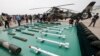 FILE PHOTO - Journalists film weapons for Chinese Army Z-9WZ attack helicopter, background, designed and manufactured by China, during a demonstration for the press at a base of Army Aviation 4th Helicopter Regiment, ahead of Army Day on Aug. 1.