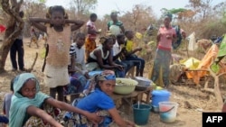 FILE - Refugees from Central Africa sit in the eastern Cameroonian village of Gado Badzere, near the city of Garoua-Boulai, not far from the border with Central Africa, March 13, 2014. 