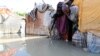 A Somali man walks out of his flooded makeshift shelter after heavy rain in Mogadishu, Somalia October 21, 2019. 