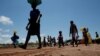 FILE - A South Sudanese refugee woman carries her belongings in a refugee settlement camp in northern Uganda, Aug. 23, 2017. 