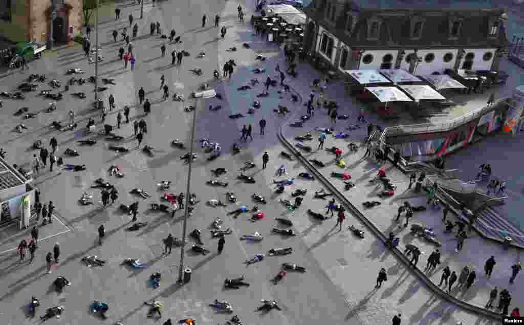 Beberapa orang berbaring di lapangan kota Frankfurt, Jerman untuk mengenang&nbsp;528 korban pembantaian di kamp konsentrasi Nazi &quot;Katzbach&quot; di Jerman.