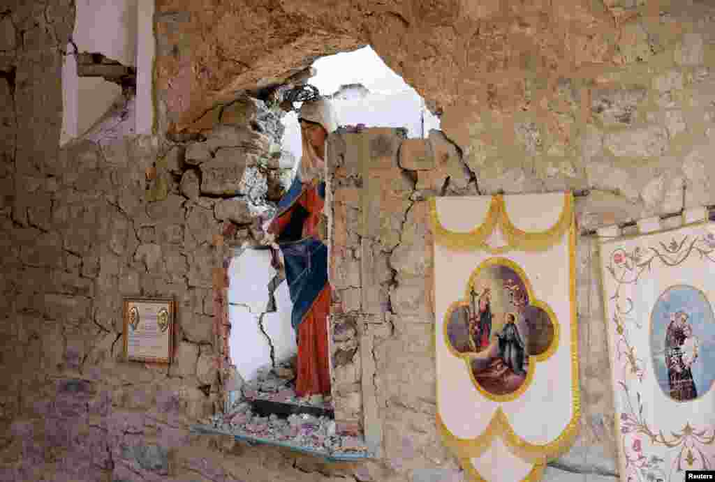 Sebuah patung Bunda Maria tampak dalam sebuah makam yang hancur setelah terjadinya gempa bumi di Sant&rsquo; Angelo dekat Amatrice, Italia bagian tengah.