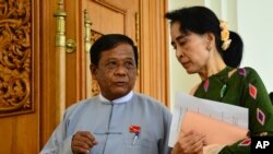 FILE - Zaw Myint Maung, left, an imprisoned politician and a close colleague of Myanmar’s ousted leader Aung San Suu Kyi, right, talks with Suu Kyi at Parliament in Naypyitaw, July 23, 2015.