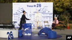 A woman walks past an open air reception of We continue the Change party, Oct. 24, 2024, in Sofia, as Bulgarians are called to cast ballots on Sunday in the seventh general elections in just over three years.