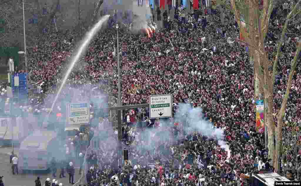 Turkish riot police use tear gas and water cannons to disperse Besiktas supporters trying to pass security barriers in front of Besiktas' new stadium, the Vodafone Arena in Istanbul, before the Turkish Super League soccer match between Besiktas Istanbul and Bursaspor.