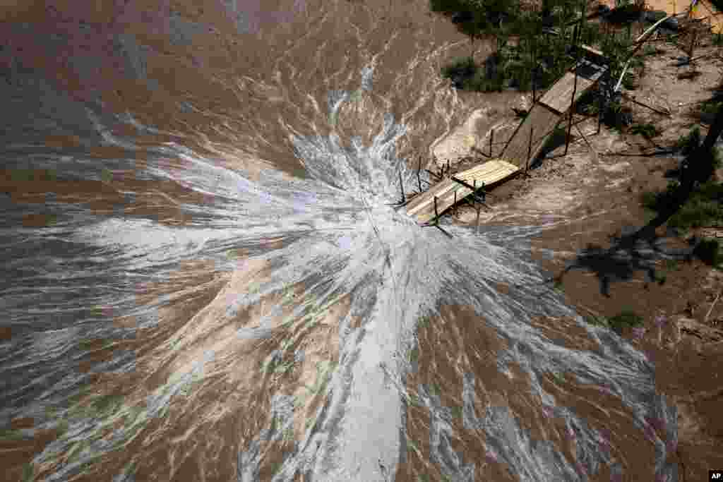 This aerial view from a police helicopter shows a &quot;tolba,&quot; a rustic, sluice-like contraption layered with pieces of carpet to capture gold deposits from water sediment, during a government raid to destroy illegal gold mining operations in the deforested area known as La Pampa in Peru&#39;s Madre de Dios region.