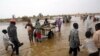 FILE - Displaced people carry their belongings to relocate to dryer areas following flooding caused by heavy rains, Nyala, Sudan, June 3, 2017. Parts of the country have been reeling from fresh floods over the past two months.