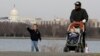 FILE - A man walks with his children during unseasonably warm weather in Washington, Feb. 22, 2017. 