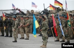 Servicemen from different countries stand at attention during an opening ceremony of the NATO-led military exercises "Noble Partner 2018" at Vaziani military base outside Tbilisi, Georgia, Aug. 1, 2018.
