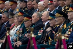 Russian President Vladimir Putin, center right, and Kazakhstan's former president Nursultan Nazarbayev, center left, attend the Victory Day military parade to mark 74 years since the end of World War II, in Red Square in Moscow, Russia, May 9, 2019.