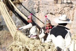 Members of the Huinchiri community rebuild an Incan hanging bridge, known as the Qeswachaka bridge, using traditional weaving techniques in Canas, Peru, June 13, 2021.