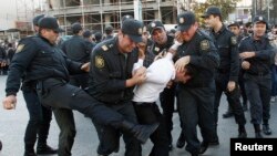 Polis müxalif nümayiş iştirakçısını döyür. Bakı, 12 oktyabr, 2013.