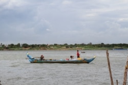 អ្នក​នេសាទ​កំពុង​ចេញ​ទូក​ទៅ​នេសាទនៅ​ទន្លេ​មេគង្គ​ ក្នុង​រាជធានី​ភ្នំពេញ នា​រសៀលថ្ងៃ​ទី​២២ ខែ​ឧសភា ឆ្នាំ​២០២១។​ (កាន់ វិច្ឆិកា/វីអូអេ)