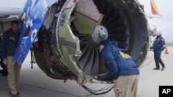 17일 미국 필라델피아 공항에서 미 연방교통안전위원회(NTSB) 소속 직원이 사고 난 사우스웨스트 비행기의 엔진을 살펴보고 있다.
