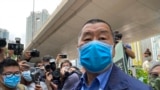 2020年5月18日，香港传媒大亨黎智英(中)戴着口罩抵达法庭。(资料照片)