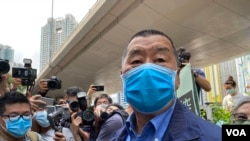 2020年5月18日，香港传媒大亨黎智英(中)戴着口罩抵达法庭。(资料照片)