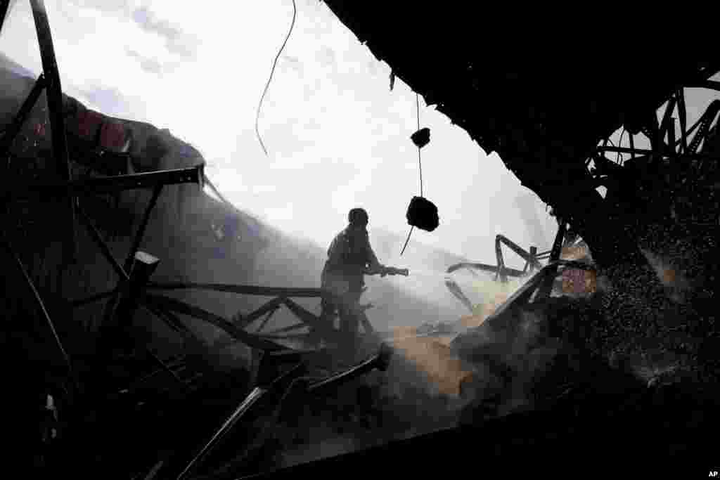 Seorang petugas pemadam kebakaran mematikan api di sebuah pabrik garmen di Gazipur, di luar Dhaka (9/10). (AP/Shuvo Das) 