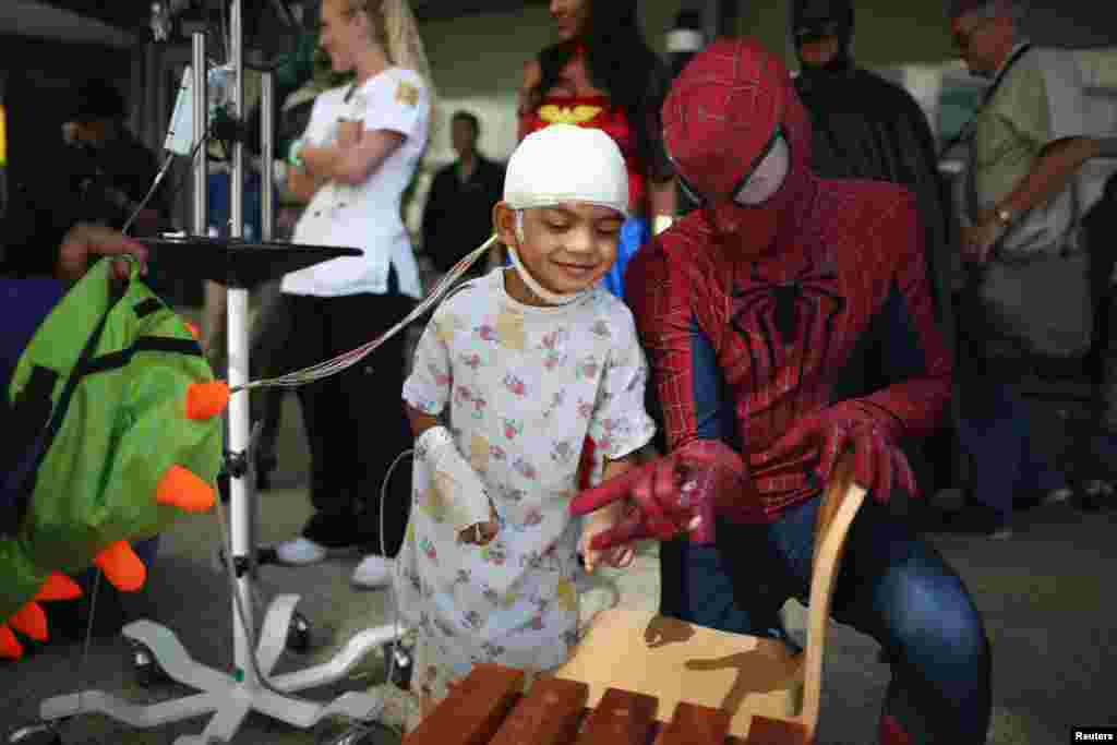 Seorang berpakaian &#39;Spider-Man&#39; menghibur pasien di rumah sakit anak Mattel di Los Angeles, California.