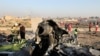 FILE - Debris is seen from a Ukrainian airliner accidentally downed by Iran, as authorities work at the scene in Shahedshahr, near Tehran, Iran, Jan. 8, 2020. 