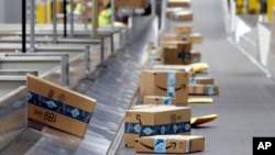 FILE - Amazon packages move along a conveyor at an Amazon warehouse facility on Dec. 17, 2019, in Goodyear, Arizona. 