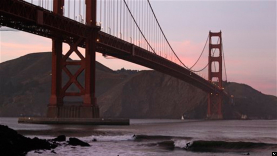 Surfers catch waves late in the day under the Golden Gate Bridge in San Francisco, Wednesday, Jan. 19, 2011. (AP Photo/Eric Risberg)