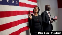 Deux nouveaux citoyens américains après avoir prêté le serment d'allégeance lors d'une cérémonie spéciale de naturalisation dans l'arrondissement de Manhattan à New York, le 13 novembre 2015.