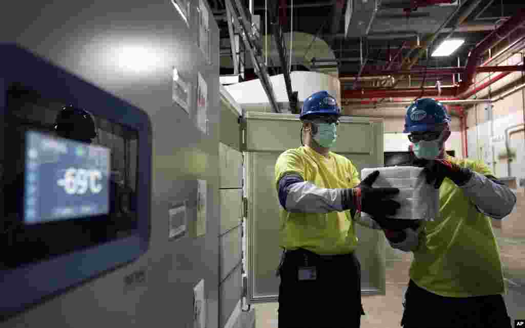 The temperature on a freezer reads -69&deg;C as workers move boxes containing the Pfizer-BioNTech COVID-19 vaccines to be shipped at the Pfizer Global Supply Kalamazoo manufacturing plant in Portage, Michigan.