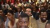 Le rappeur Luaty Beirão, deuxième à droite sur la deuxième rangée, est assis au milieu d'autres opposants et activistes lors de leur procès au tribunal de Luanda, Angola, 16 novembre 2016.