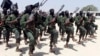 FILE - Hundreds of newly trained al-Shabab fighters perform military exercises in the Lafofe area, south of Mogadishu, Somalia.