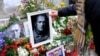 A woman places a portrait of late Russian opposition leader Alexey Navalny, who died unexpectedly in prison, on his memorial at Las Ramblas of Barcelona, in Barcelona, Spain, Feb. 25, 2024.