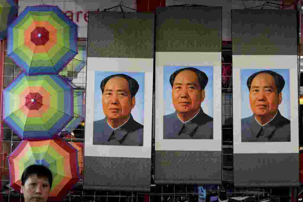 Seorang wiraniaga duduk dekat poster pemimpin komunis Almarhum Mao Zedong yang diperagakan di sebuah toko dekat Lapangan Tiananmen di Beijing.&nbsp; Hari Jum&rsquo;at merupakan peringatan 40 tahun meninggalnya pemimpin yang mendirikan Republik Rakyat China tahun 1949 dan menjadi penguasa tanpa oposisi hingga 1976.
