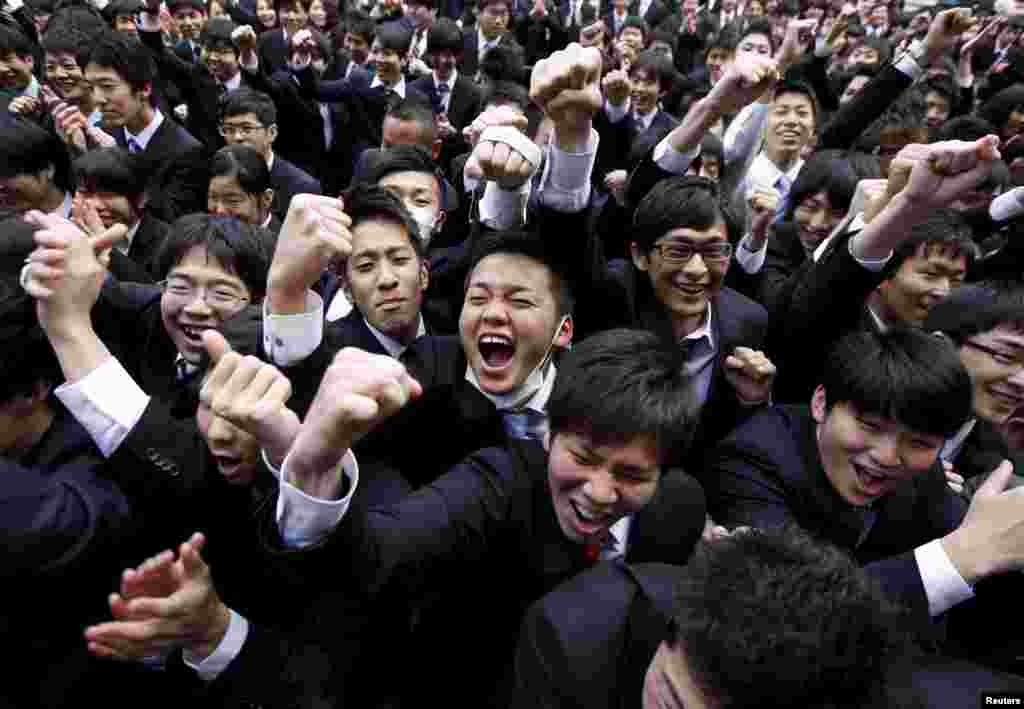 Japanese college students shout and raise their fists during a rally held to boost their morale ahead of their job hunt, at an outdoor theater in Tokyo.