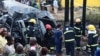 Firefighters assess debris at the scene of an explosion after a fuel tanker rolled and residents started to siphon fuel, in Kigoogwa suburb, Wakiso district on the outskirts of Kampala, Uganda, Oct. 22, 2024.