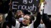 A woman holds a sign as protesters gather in Sydney, Tuesday, June 2, 2020, to support the cause of U.S. protests over the death of George Floyd and urged their own governments to address racism and police violence.