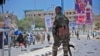 Un membre des services de sécurité somaliens patrouille sur les lieux d'un attentat suicide à la voiture piégée à Mogadiscio, le 30 août 2016.