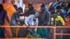 Sejumlah migran turun dari kapal di pelabuhan La Restinga di Kepulauan Canary, Spanyol, pada 3 Desember 2024, setelah berhasil diselamatkan oleh tim SAR Spanyol di perairan laut lepas. (Foto: AFP/Antonio Sempere)